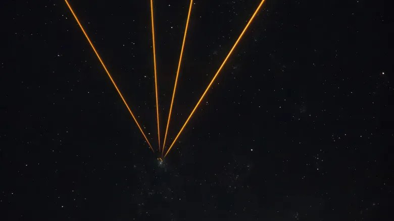 Lasers target the Tarantula Nebula with artificial stars photo of the day for Nov. 19, 2025 A series of golden lines converging to one point in a starry night in the center of the image